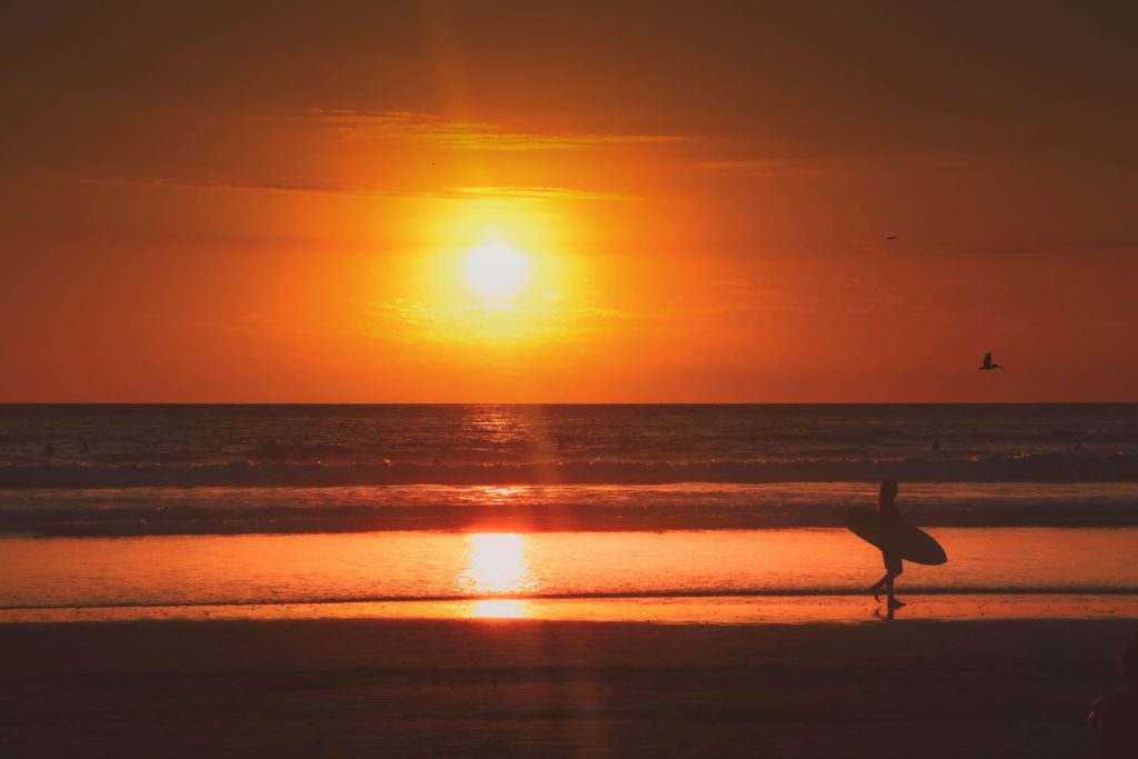 Surfer at sunset in Nosara, Costa Rica