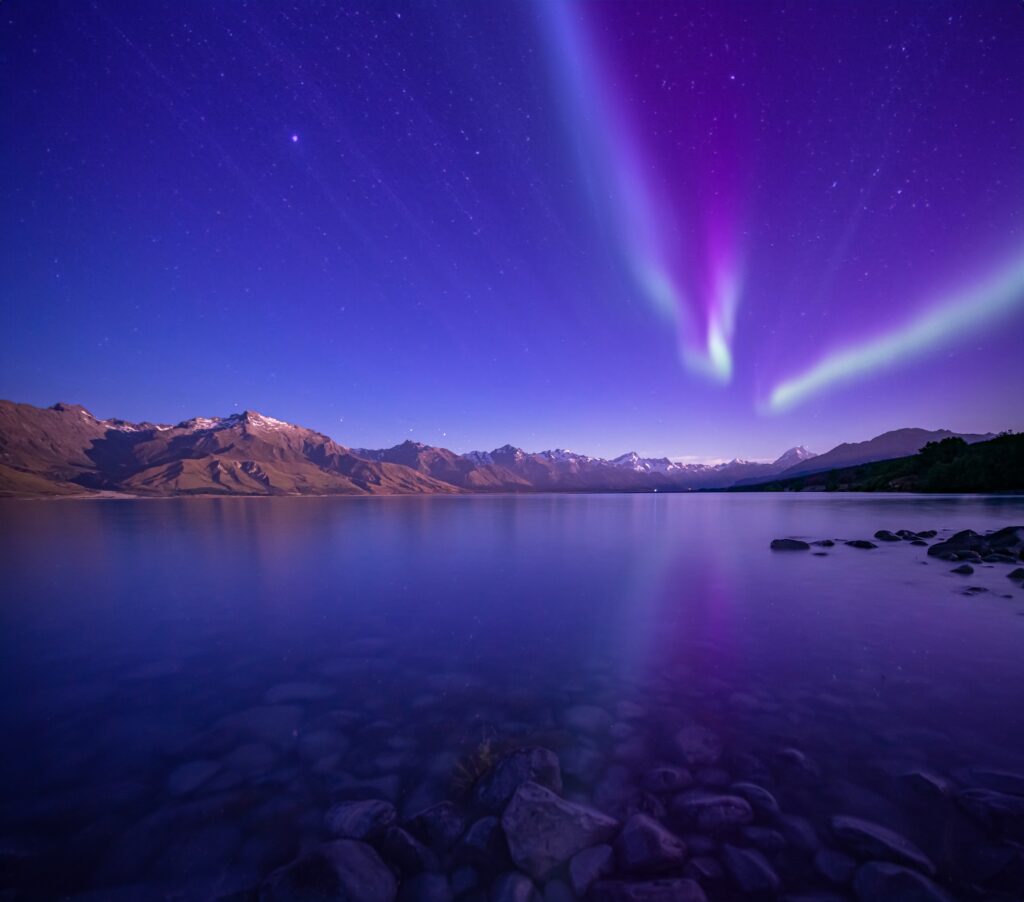 Auroras in the night sky over the Southern Alps of New Zealand.
