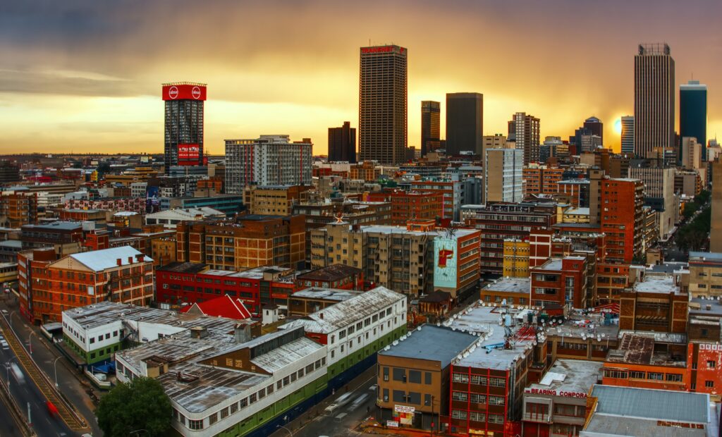 A view of Johannesburg at dawn, with some haze across the sky and color downtown buildings.